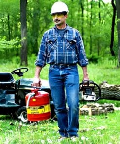 Mężczyzna w kasku ochronnym i okularach, trzymający piłę łańcuchową oraz pojemnik na paliwo, w lesie. Ubrany w niebieską koszulę w kratę i dżinsy, na tle zielonych drzew i ściętych pni. Obraz ilustruje aspekty bezpieczeństwa pracy w ekologicznym kontekście.