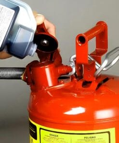 Osoba napełniająca gaśnicę płynem gaśniczym z niebieskiego pojemnika. Na gaśnicy widoczne są ostrzeżenia dotyczące bezpieczeństwa. Ważny element bezpieczeństwa pracy i procedur awaryjnych w ochronie środowiska.