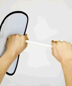 Dwie ręce trzymają białą rurkę, która jest przymocowana do okrągłego elementu. Obraz ilustruje zasady bezpieczeństwa w pracy z użyciem sprzętu ochronnego.