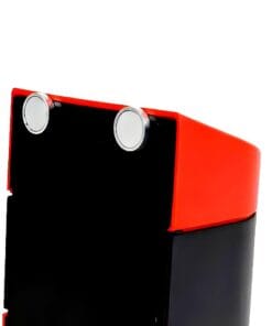 Zbliżenie na czarno-czerwoną obudowę urządzenia, z metalowymi okrągłymi przyciskami u góry. Urządzenie może być związane z bezpieczeństwem pracy lub środkami awaryjnymi, podkreślając znaczenie ochrony środowiska.