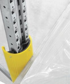 Zbliżenie na metalowy wspornik z żółtą osłoną gumową, który zabezpiecza krawędź przejrzystej folii. Elementy służą do ochrony przed zranieniem i polepszają bezpieczeństwo pracy w środowisku magazynowym. Zdjęcie ilustruje zastosowanie środków awaryjnych w logistyce.