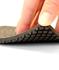 Zbliżenie na elastyczną podeszwę buta, pokazującą strukturę i wzór bieżnika, z palcem trzymającym jej krawędź. Skupienie na detalu materiału, który wpływa na komfort użytkowania oraz bezpieczeństwo pracy.