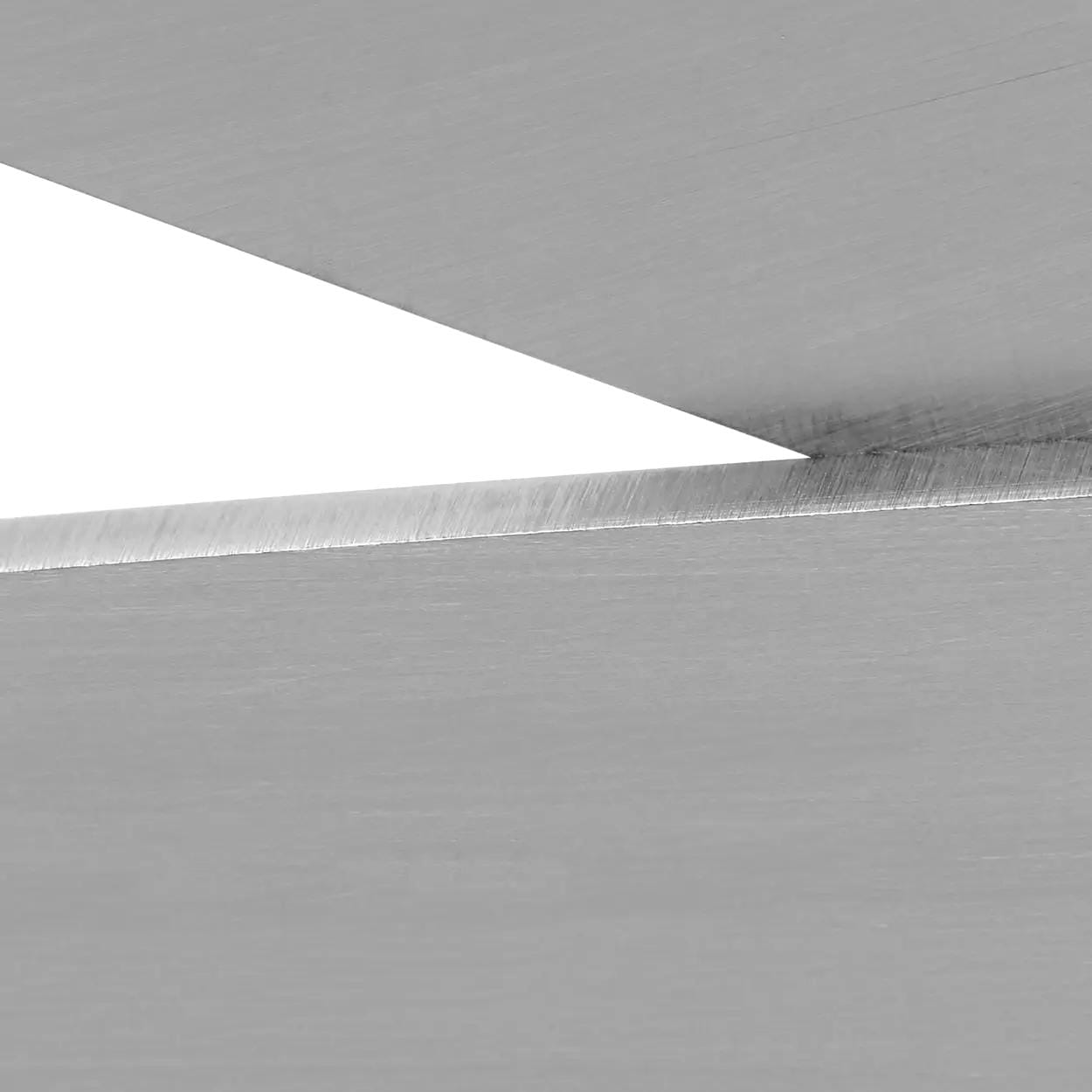 Zbliżenie na dwie stalowe powierzchnie z widocznym ostrym krawędziami, podkreślające precyzyjne cięcie i gładkość materiału. Idealne w kontekście zastosowań w bezpieczeństwie pracy i ochronie środowiska.