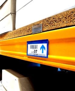 Zdjęcie przedstawia oznaczenie poziomu w magazynie. Widoczny znak "Level 07" z nadrukowanym kodem kreskowym wskazuje na lokalizację półki z kartonami. Kolorowe oznakowanie oraz zamontowana półka z płytą wskazują na dbałość o organizację i bezpieczeństwo pracy w obszarze logistyki.