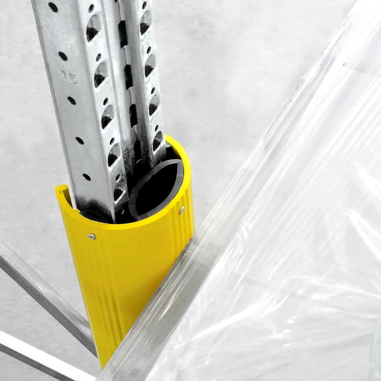 Zbliżenie na metalowy wspornik zabezpieczony żółtą osłoną, który jest częścią konstrukcji. Widok pokazuje szczegóły mocowania oraz elementy ochronne, istotne dla bezpieczeństwa pracy na budowie i ochrony środowiska.