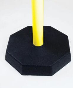 Szary, ośmiokątny ciężarek z czarnego materiału z żółtą, prostokątną rurą w środku, służący jako element bezpieczeństwa w miejscu pracy, podnoszący widoczność oraz wskazujący zagrożenia.