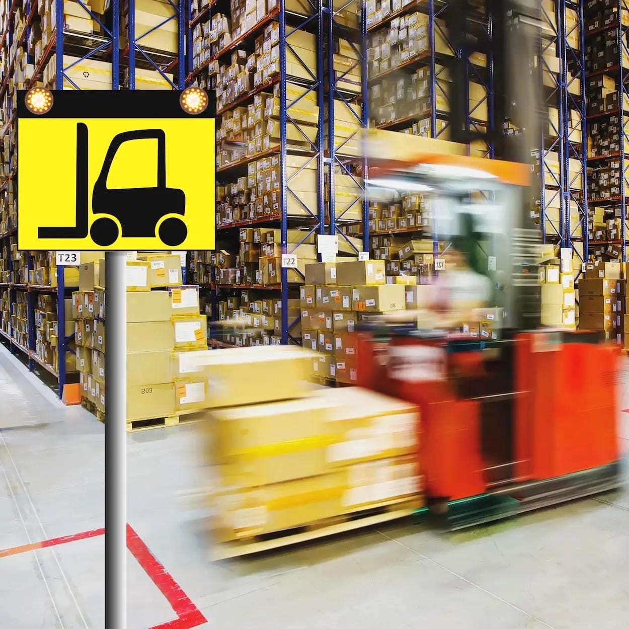 Znaki wskazujące na obecność wózka widłowego w magazynie, z tłem pełnym paczek i regałów. Scena ukazuje dynamiczną atmosferę przestrzeni magazynowej, skupiając się na bezpieczeństwie pracy i ruchu wózków widłowych.