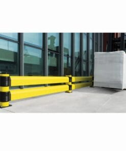 Zabezpieczenie w postaci żółtych barier na terenie zakładu, obok którego wózek widłowy transportuje paletę z towarem. Bariera ma na celu zwiększenie bezpieczeństwa pracy oraz ochronę środowiska w obszarze magazynowym.