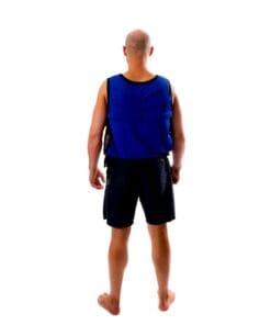 Mężczyzna w niebieskiej kamizelce ochronnej stoi tyłem, na boso, w krótkich spodenkach. Tło jest białe, co podkreśla znaczenie bezpieczeństwa pracy i działań awaryjnych. Idealne dla tematów dotyczących ochrony środowiska i ekologii.