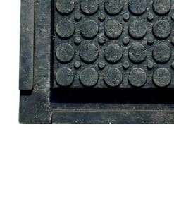 Zdjęcie czarnej maty z wypustkami w kształcie okręgów, używanej w kontekście bezpieczeństwa pracy lub jako element ochrony środowiska. Wzór maty zapewnia lepszą przyczepność i ochronę przed śliskimi powierzchniami.