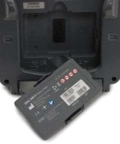 Bateria do automatycznego defibrylatora ZOLL AED 3, przedstawiona z tyłu urządzenia. Na etykiecie szczegóły dotyczące zasilania, bezpieczeństwa i oznaczenia produkcji. To istotny element w kontekście środków awaryjnych w ochronie zdrowia.