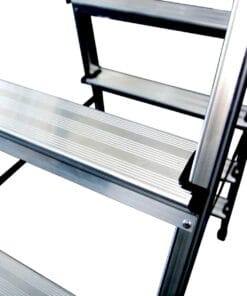 Zbliżenie metalowych stopni drabiny, z widocznymi, rowkowymi powierzchniami zapewniającymi przyczepność. Elementy konstrukcyjne są solidne i odporne, co podkreśla ich zastosowanie w kontekście bezpieczeństwa pracy i efektywności.