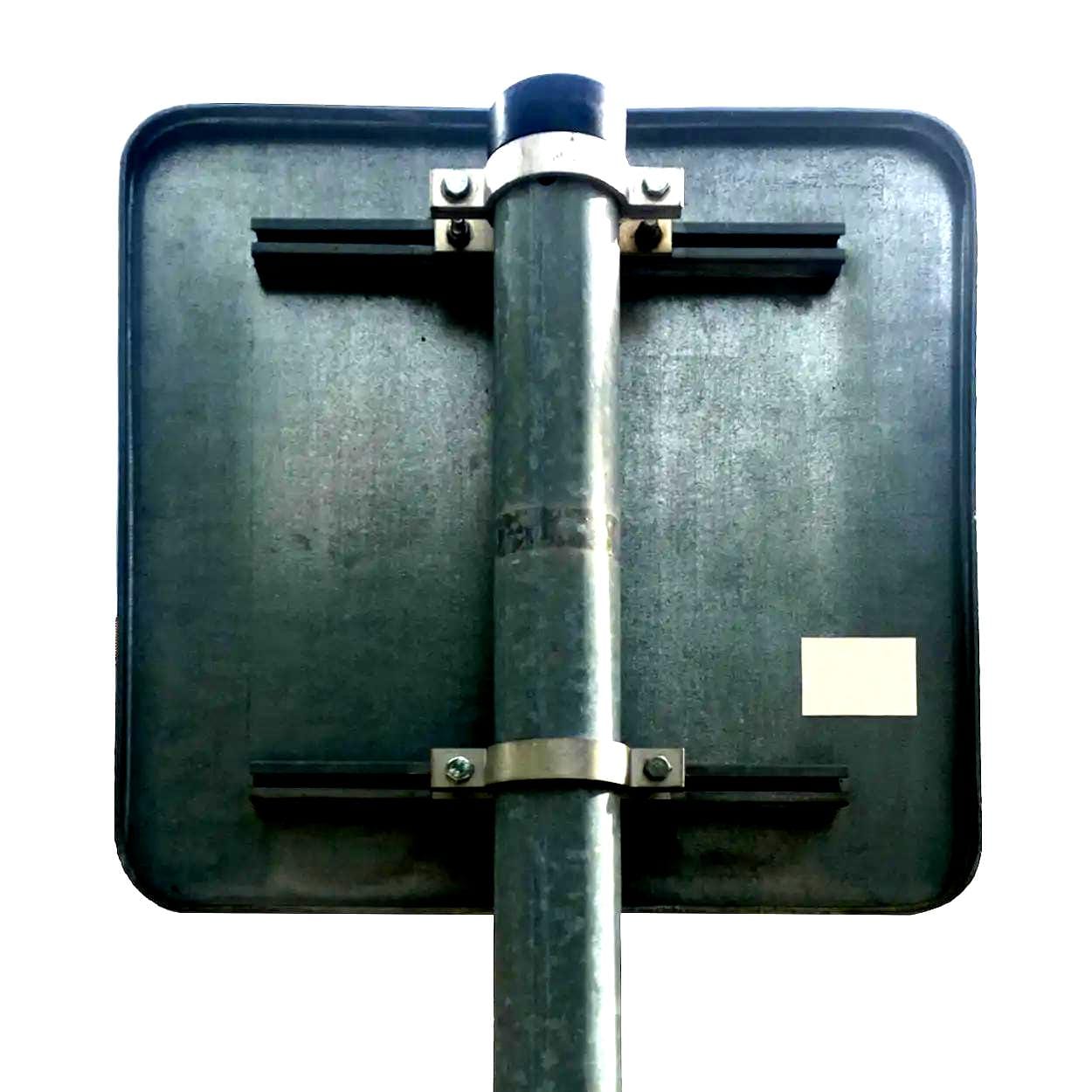 Zdjęcie betonowego znaku drogowego widocznego z tyłu, mocowanego do metalowego słupa. Elementy konstrukcyjne pokazują solidność i trwałość, co jest istotne w kontekście bezpieczeństwa pracy oraz ochrony środowiska.