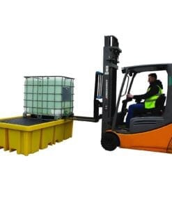 Wózek widłowy podnosi zbiornik na ciecz, umieszczony na żółtej platformie. Pracownik w odzieży roboczej z kamizelką odblaskową obsługuje maszynę, co podkreśla znaczenie bezpieczeństwa w pracy i odpowiednich środków awaryjnych w kontekście ochrony środowiska.